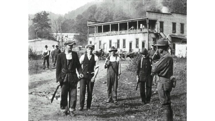 photo of unionized coal miners at Blair Mountain surrendering their weapons in 1921 (public domain)